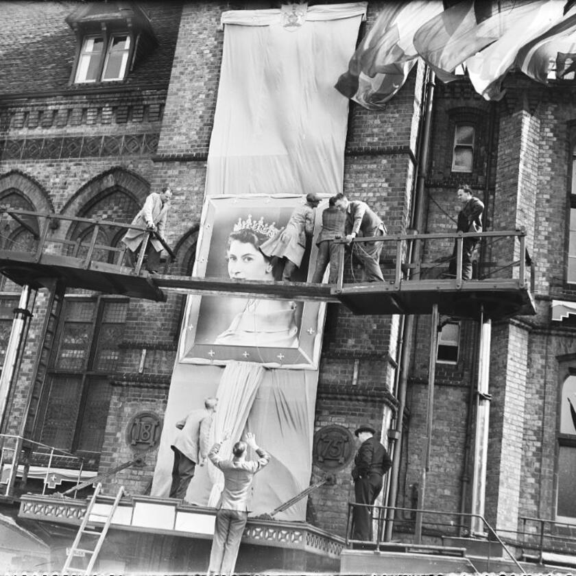 Putting up Coronation decorations at the Town Hall, May 1953. (Object number REDMG : 1980.36.B653.1).